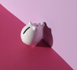 Wall Mural - White ceramic piggy bank on a pink background with shadow