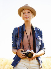 Wall Mural - Field, photography and woman with a camera, travel and thinking with ideas, nature and memory. Person, countryside and girl with tourism, photographer and journey with sunshine, adventure and picture