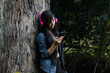 © Yoel Garay - Mujer joven atractiva con auriculares disfrutando de música o un podcast en el parque o bosque, que encarna la relajación, la felicidad y la actividad de ocio. Estilo de vida saludable.