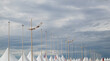 White pavilions with several light poles and cloudy sky on the background