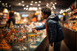 Curious young boy observing detailed miniature models in a warmly lit toy store with wonderment.