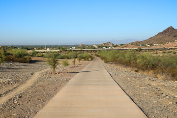 Wall Mural - Dreamy Draw preserve dirt hiking trails and paved bike path near Arizona State Route 51 highway with a distant view of Phoenix downtown, Arizona