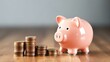 © Sariyono - Piggy bank and coins on wooden table, business and finance concept