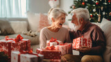 Fototapeta  - Senior Couple Exchanging Gifts As They Celebrate Christmas At Home With Family