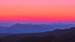 Bergpanorama im Abendlicht: Lila Berggipfel vor brennendem Sonnenuntergang