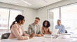 © insta_photos - Happy international executive board work group talking at office meeting. Busy diverse professional colleagues team consulting managing strategy, having discussion at corporate boardroom table.