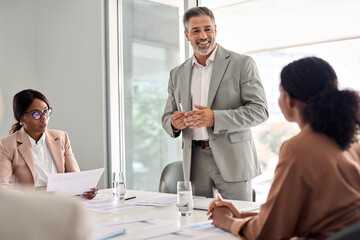 Aufkleber - Busy older manager leader and company employees at business meeting discussing corporate management. International professional business people board team at boardroom office table.