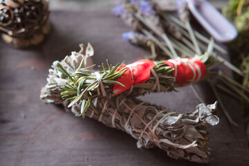 woman doing traditional ritual with herbs tying them with cotton thread accompanied by incense