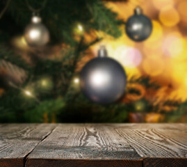 Wooden table near beautifully decorated Christmas tree. Space for design