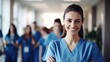 Portrait of a smiling nurse standing in front of her team.