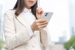 © oka - スマートフォンを操作するビジネスウーマン　ボディパーツ