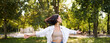 Freedom and people concept. Happy young asian woman dancing in park around trees, smiling and enjoying herself