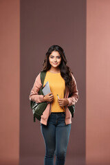 Wall Mural - Young indian college girl holding books in hand, smiling