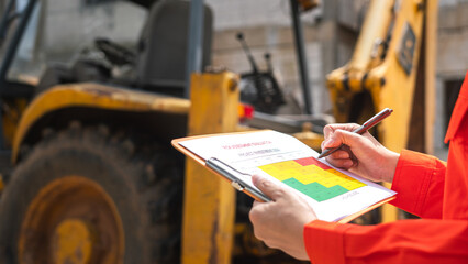 Wall Mural - the operation supervisor is using ballpoint pen to marking on the risk assessment matrix form, to in