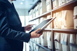 © Anoo - Photo of a businessman holding a tablet in a sophisticated office settingA businessman checks information in the archive. a man with an electronic tablet works in the archive.