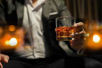 Wall Mural - Closeup businessmen holding a glass of whiskey