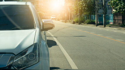 Front of white car stop beside of asphalt road. Empty road in the city at day. Copy space on the road for background.