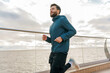 Fitness trainer active lifestyle for health. A man runs alone training in the cold. Athlete jogging in warm sportswear for autumn.