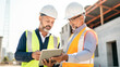 © BlazingDesigns - Construction worker engineer digital tablet talking at construction site.