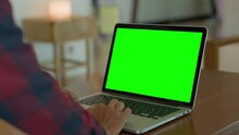 Over The Shoulder Shot Of Woman, Using Finger With Keyboard For Typing Touch. Computer Laptop With Blank Green Screen Chroma Key In Cafe.
