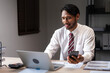 © Pichsakul - Businessman researching data on smartphone and typing on laptop while analyzing strategy of startup