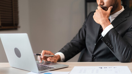 Wall Mural - Businessman typing data on laptop while thinking and analyzing strategy of new startup business