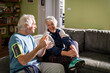 © Marko Geber - Senior couple sharing a joyful moment with a smartphone before their exercise session