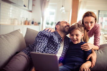 Wall Mural - Young family with laptop on the couch