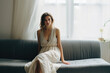 © Konstiantyn Zap - A forlorn young lady stands near the window, her eyes reflecting the depth of her sadness, encapsulating the essence of female melancholy