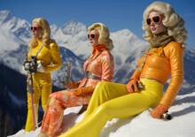 Three Women In Ski Gear On A Snow Covered Mountain.