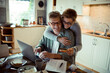 © Davor - A joyful senior couple shares a moment while making an online purchase at home