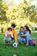 © Ladanifer - Latin family with two children soccer ball and balance bike in a park. Hispanic family.