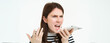 © Mix and Match Studio - Portrait of angry woman shouting at smartphone speakerphone, recording voice message with annoyed face expression, screaming at phone, white background