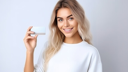 Wall Mural - Portrait of smiling happy young blonde girl showing plastic credit card on white background. woman holding credit card with copy space. mockup. ai.