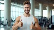 Portrait of a handsome male bodybuilder on the fitness gym background showing thumb up. personal sports trainer smiling and looking at camera. ai.