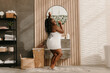 © gstockstudio - Full length of playful plus size African woman covered in towel dancing and singing in domestic bathroom
