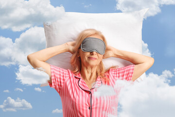 Wall Mural - Woman in pajamas with a mask on eyes sleeping on a pillow