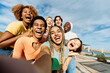 © alvaro - Happy and excited multicultural friends taking a selfie outdoors