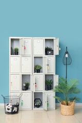 Canvas Print - Modern locker with plants and lamp near blue wall