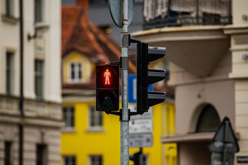 Poster - Red pedestrian traffic light forbidden to go with European city in the background