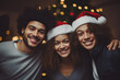 un hombre y dos mujeres con sombrero de papá noel  con fondo desenfocado de decoración navideña
