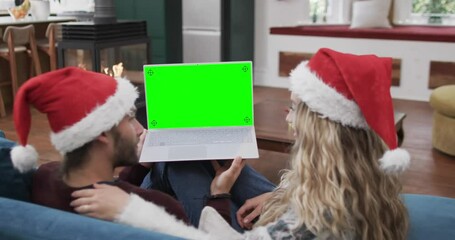 Poster - Happy caucasian couple having christmas laptop video call with green screen, slow motion