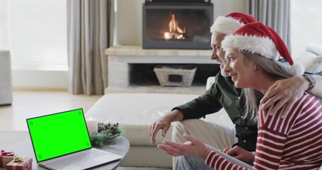 Sticker - Happy caucasian couple having christmas laptop video call with green screen, slow motion