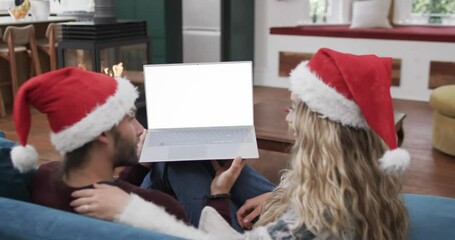 Canvas Print - Happy caucasian couple having christmas laptop video call with copy space, slow motion