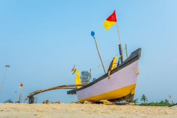 old fishing boats in the sand on the ocean in India on blue sky background