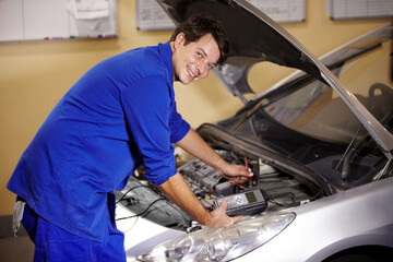 Poster - Portrait, car and repair with a mechanic man in a workshop as an engineer looking at the engine of a vehicle. Garage, service or quote with a young technician working under the hood of an automobile