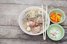 Stewed Pork Soup With Meat Balls And Vegetables In Bowl, Chopsticks On Top, Old Wooden Background. Concept, Traditional Food. Favorite Menu That Can Cook Or Order In Noodle Foodshops In Thailand.     