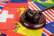 Wooden gavel on countries flags background. International laws and political decisions concept.