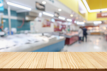 Wall Mural - Empty wood table top with supermarket blurred background for product display