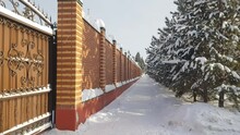 4k, Video, Modern Brick Fence Along A Snow-covered Sidewalk, In Front Of A Row Of Tall Fir Trees, Urban Landscape